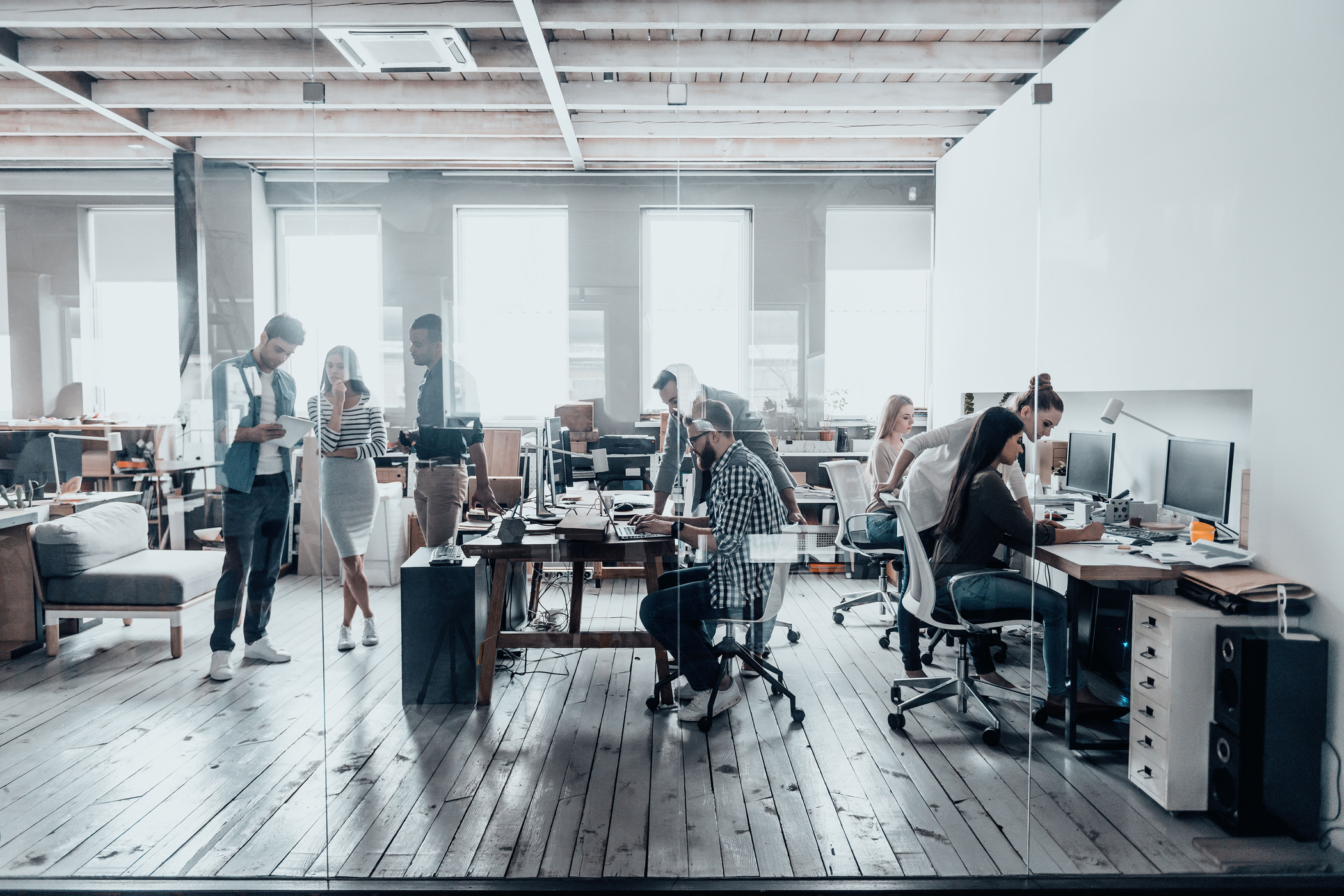 Enterprise employees working in an open office and utilizing enterprise AI to streamline business operations