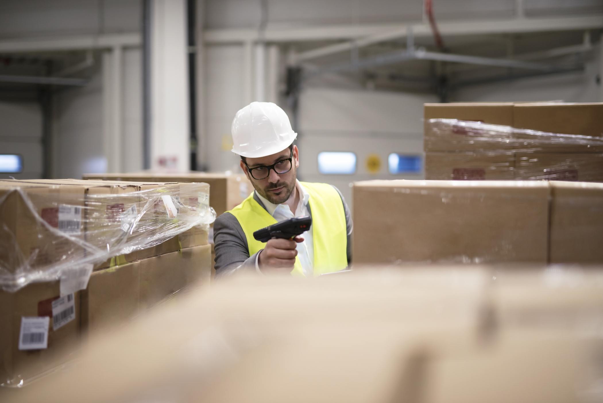 Retail warehouse worker scanning boxes to ship to customers. Using retail IT infrastructure to streamline retail operations.