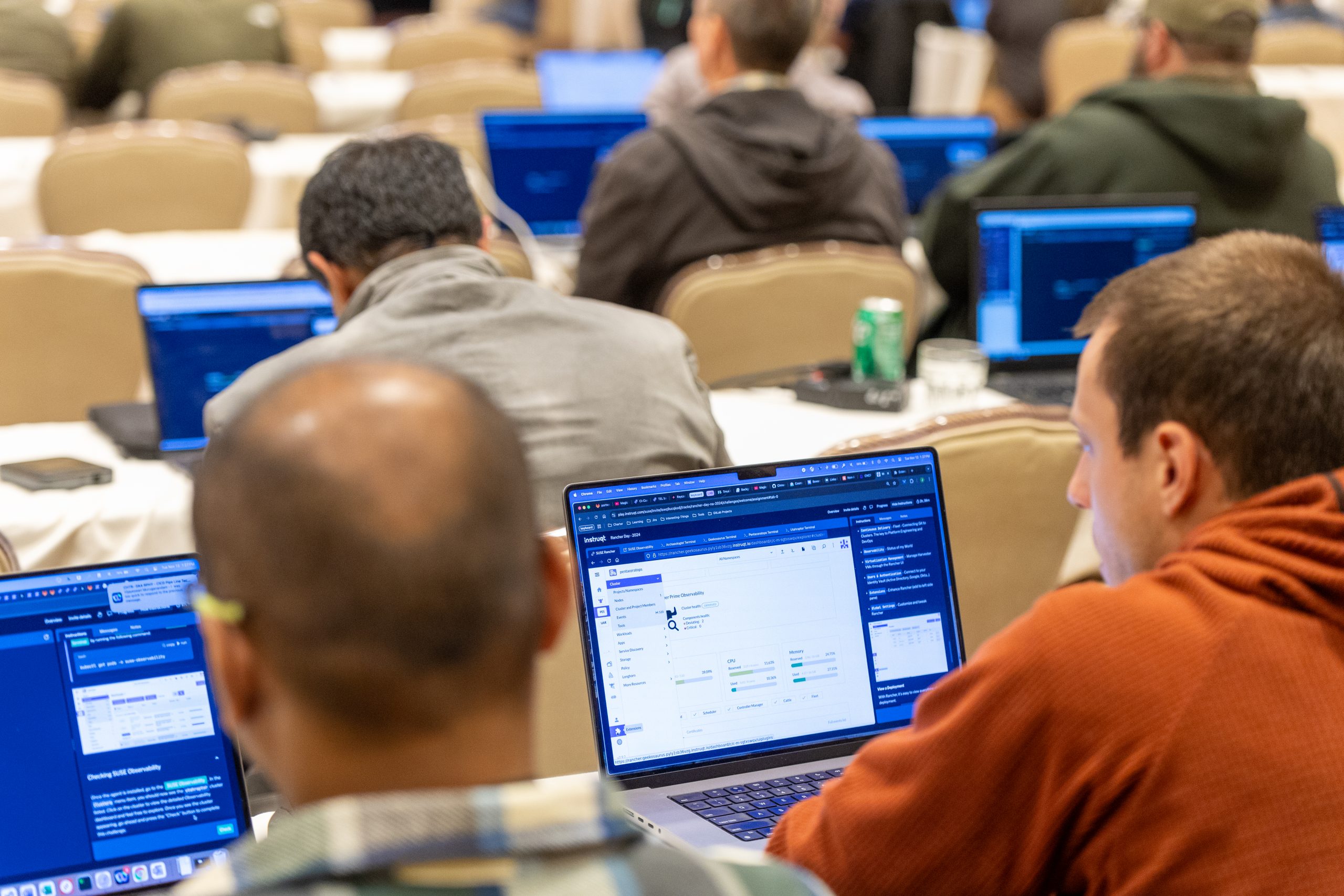 Event attendees try SUSE Rancher Prime, a container management system, on laptops